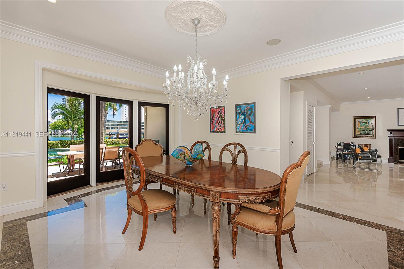 6535 Allison Road Miami Beach, FL 33141 - Photo 27 of 60 a dining room with furniture a chandelier and wooden floor