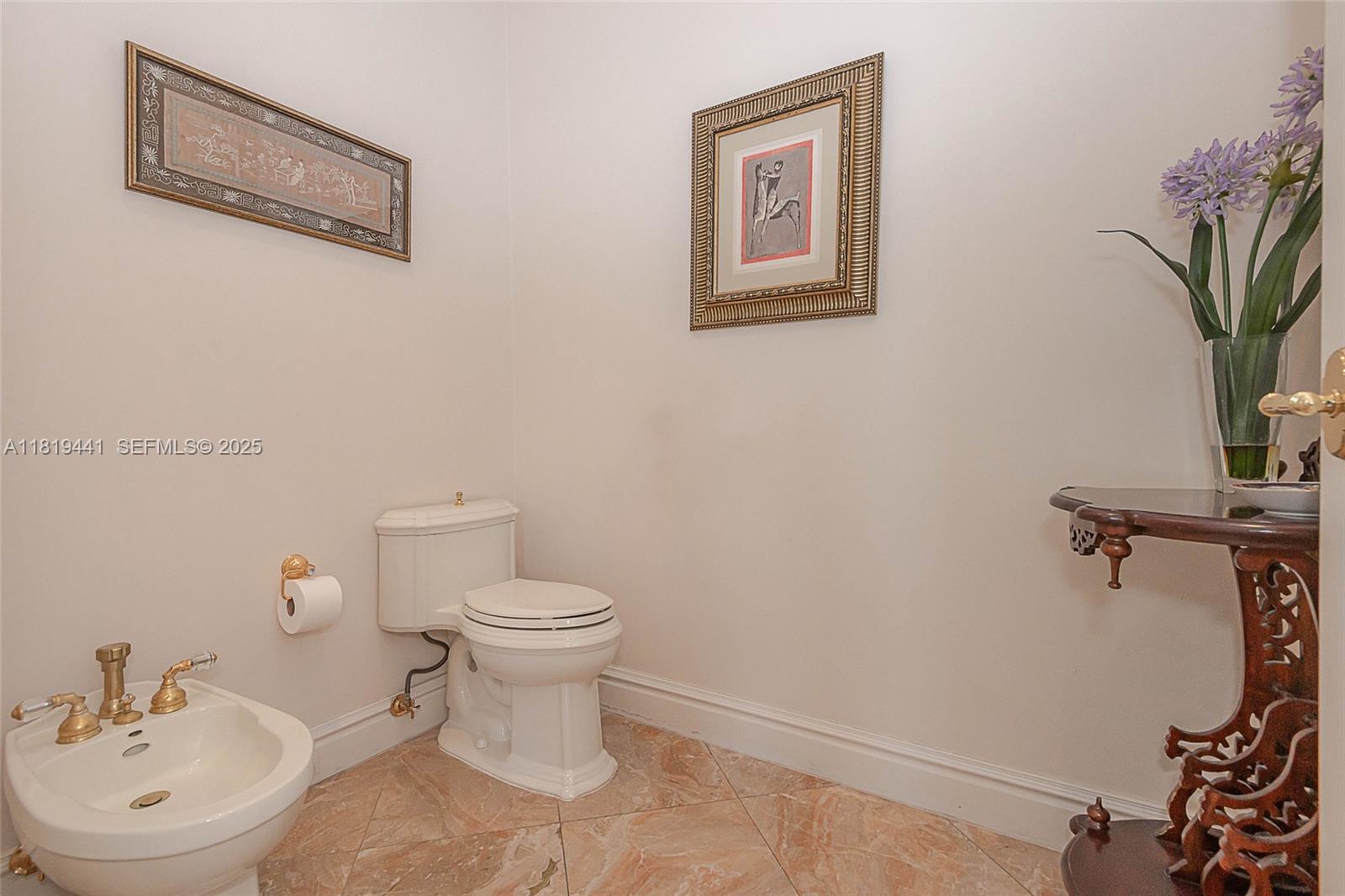 6535 Allison Road Miami Beach, FL 33141 - Photo 36 of 60 a bathroom with a toilet a sink and a mirror