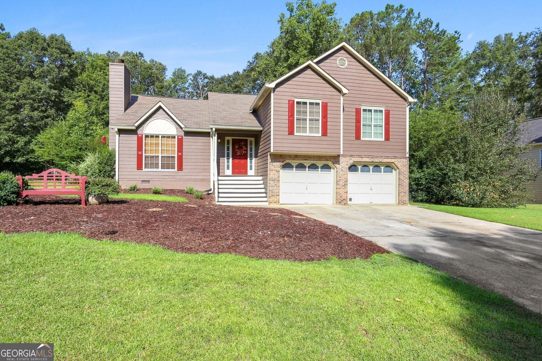 a front view of a house with a garden and yard