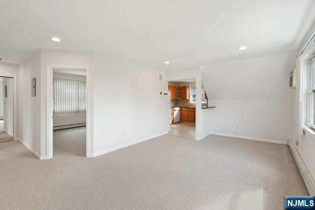 39 Springfield Avenue, Unit 2 Hasbrouck Heights, NJ 07604 - Photo 2 of 13 an empty room with a kitchen and stainless steel appliances