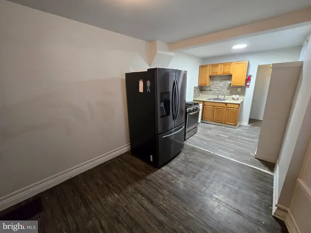 a kitchen with a refrigerator and a stove top oven