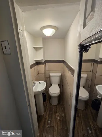 a white toilet sitting next to a sink and a mirror