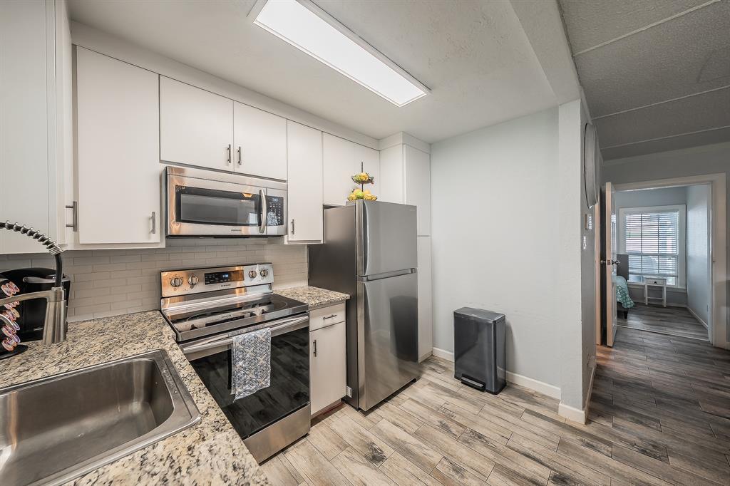 14064 Rucker Street Azle, TX 76020 - Photo 12 of 40 a kitchen with granite countertop a refrigerator stove and microwave