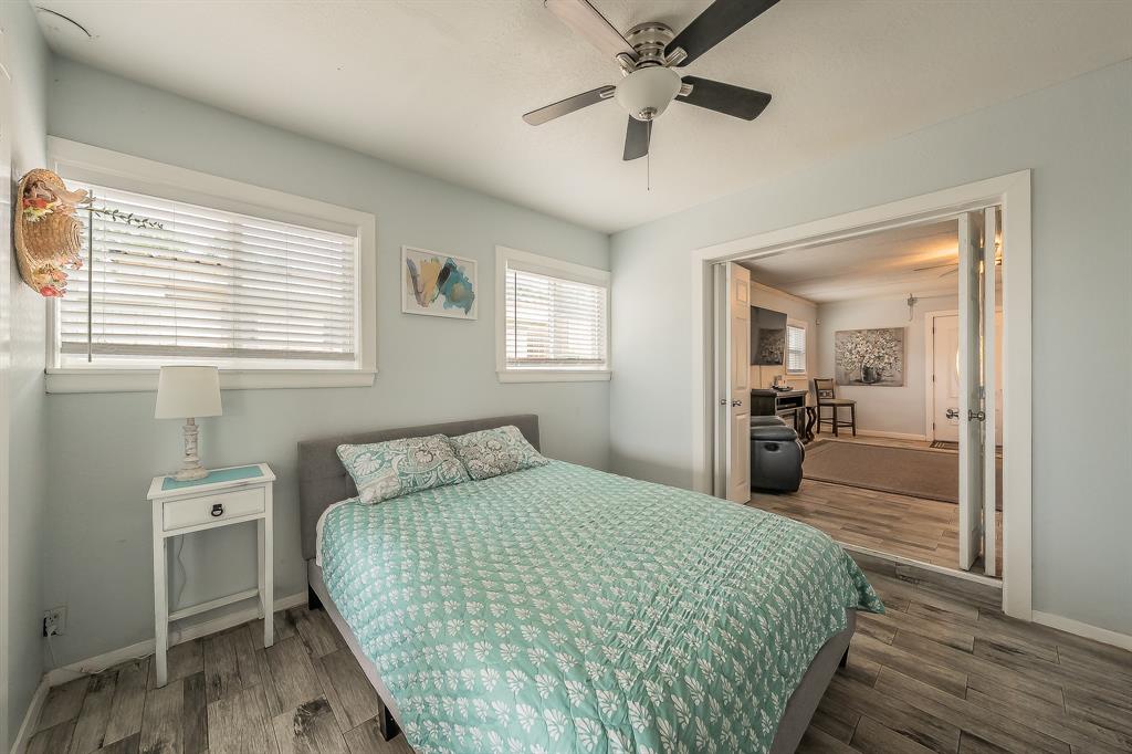 14064 Rucker Street Azle, TX 76020 - Photo 20 of 40 a bedroom with a large bed and a chandelier