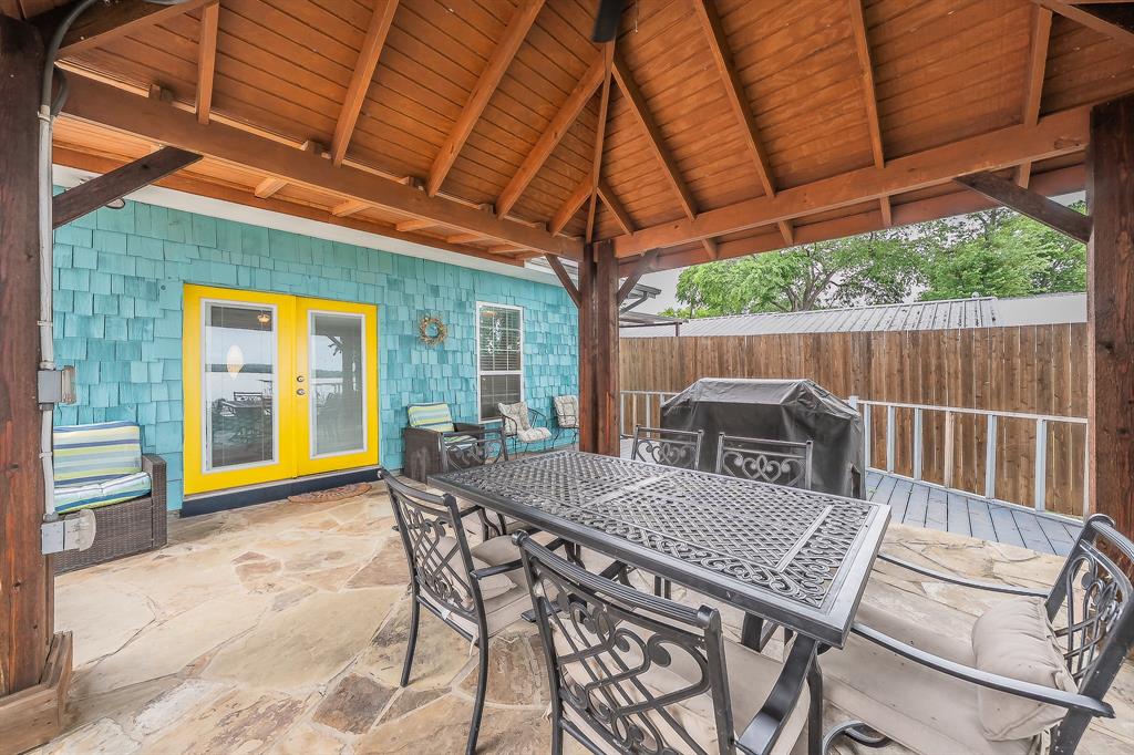 14064 Rucker Street Azle, TX 76020 - Photo 25 of 40 a view of a patio with a table and chairs under an umbrella with a small yard