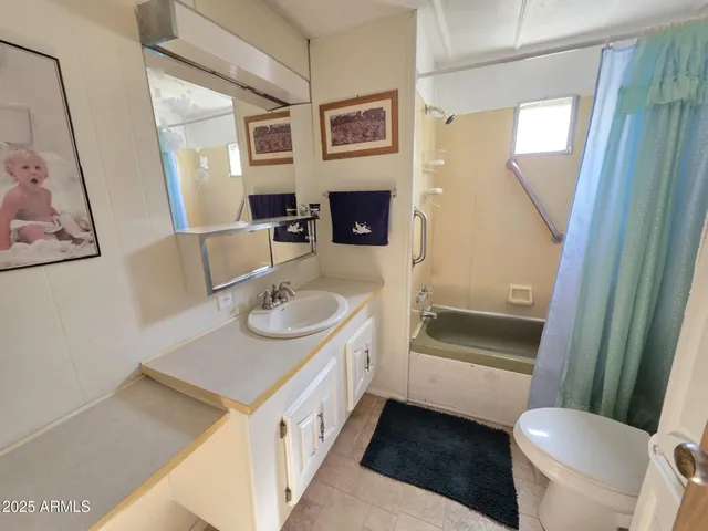 a bathroom with a sink a toilet a mirror and shower