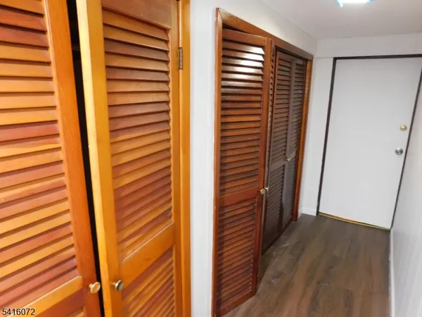a view of a hallway with wooden floor and a window