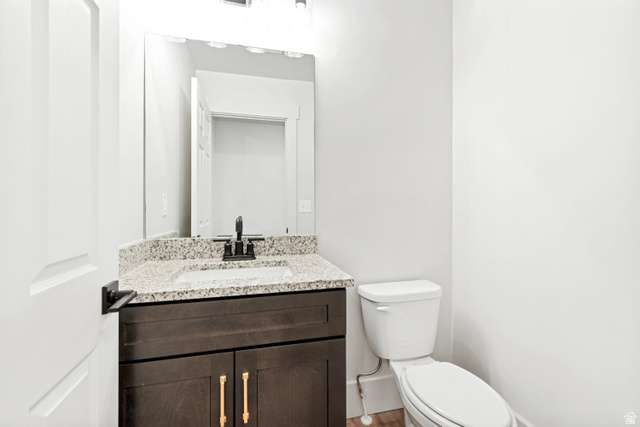 529 North Hvn Drive Mapleton, UT 84664 - Photo 14 of 30 Powder room featuring a dark wood-finish vanity with gold-tone hardware, a light granite-look countertop, and a rectangular undermount sink with a matte black faucet