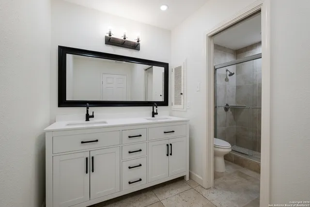 a bathroom with a toilet sink and mirror