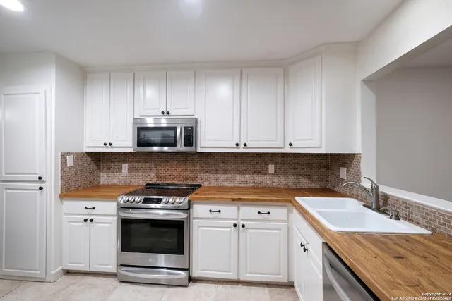 a kitchen with granite countertop a stove sink and cabinets