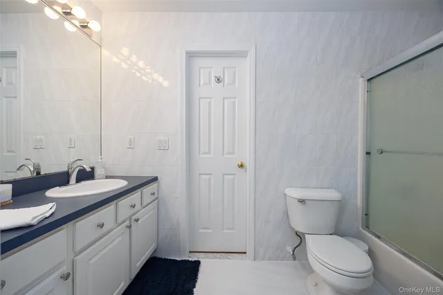 a bathroom with a toilet a sink a mirror and vanity