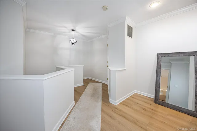 a view of empty room with wooden floor and ceiling fan