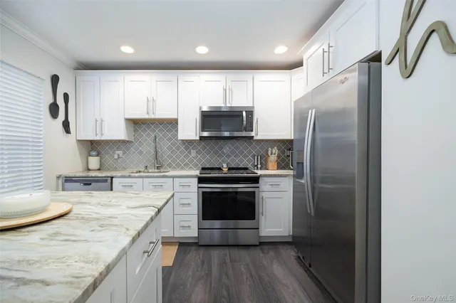 a kitchen with stainless steel appliances granite countertop a stove a refrigerator and a sink