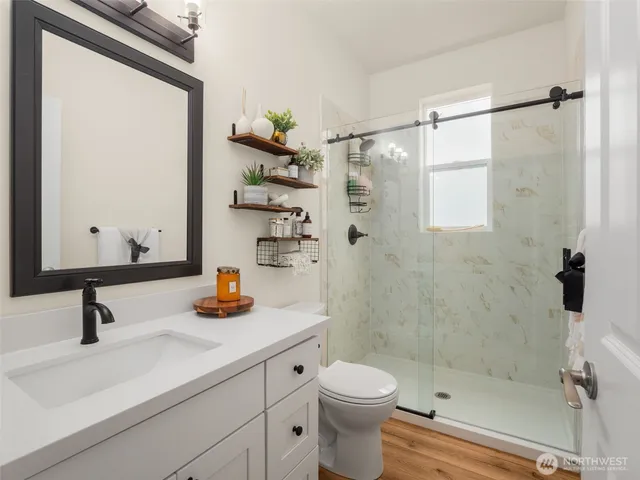 a bathroom with a sink a toilet and shower