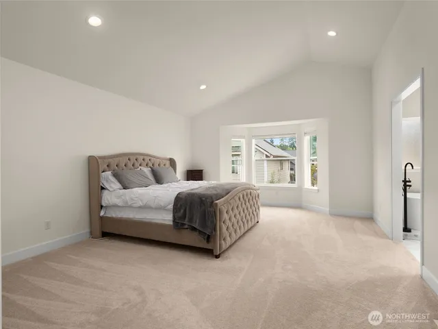 a bedroom with a large bed and wooden floor