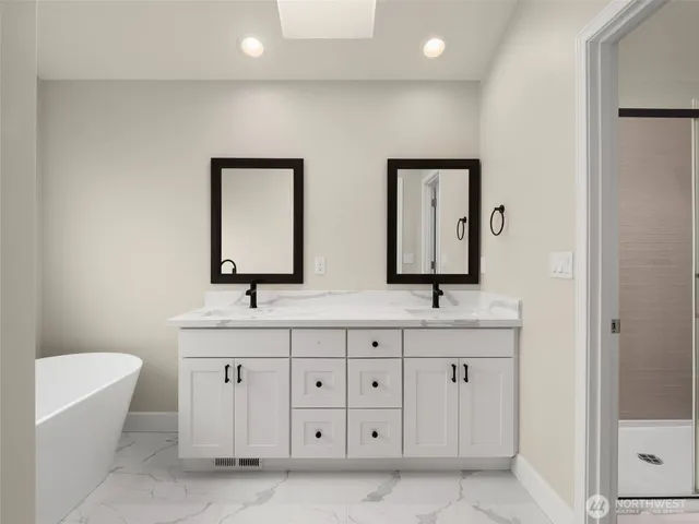 a bathroom with 2 sink tub and a mirror