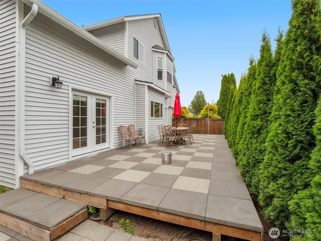 a view of a patio with a table and chairs and potted plants