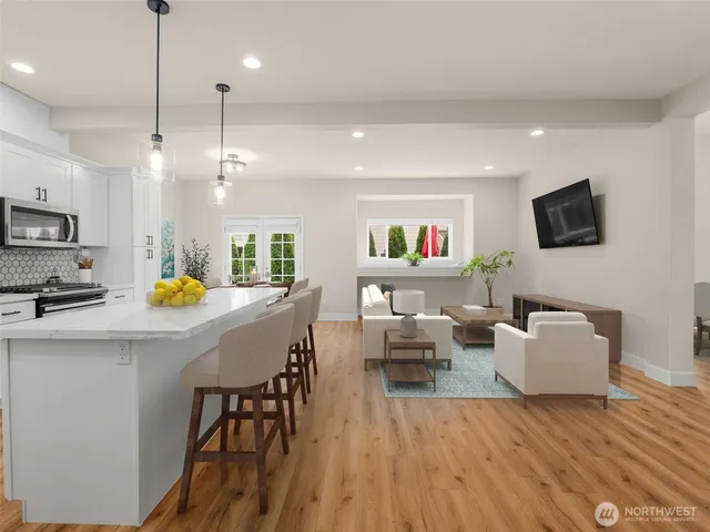 a living room with furniture a flat screen tv and kitchen view