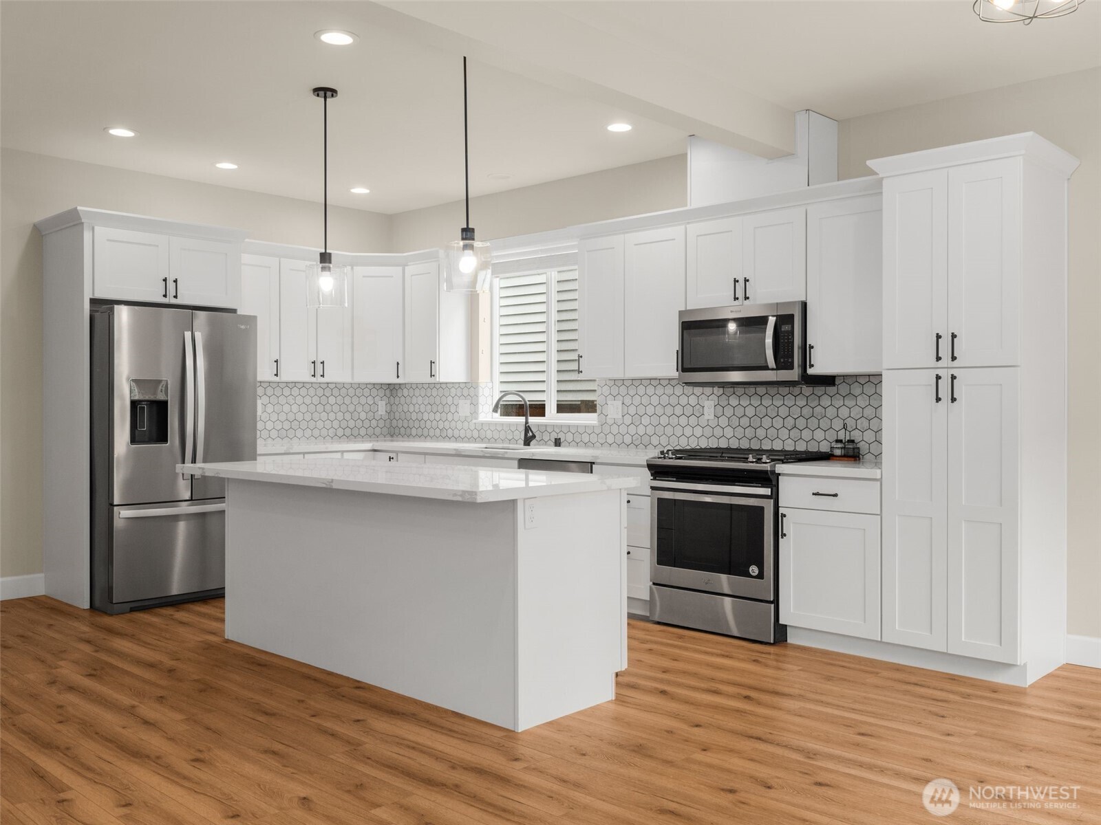 4620 151st Place Southeast Bothell, WA 98012 - Photo 6 of 33 a kitchen with stainless steel appliances granite countertop a refrigerator a stove a sink and white cabinets with wooden floor