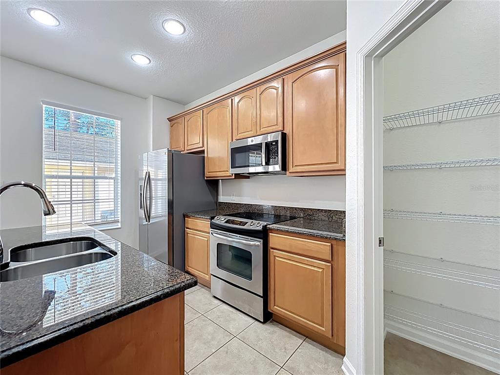 12930 Vennetta Way Windermere, FL 34786 - Photo 7 of 38 a kitchen with stainless steel appliances granite countertop a stove a sink and a microwave