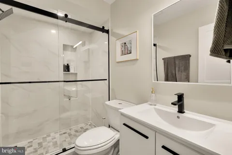 a bathroom with a sink toilet a mirror and shower