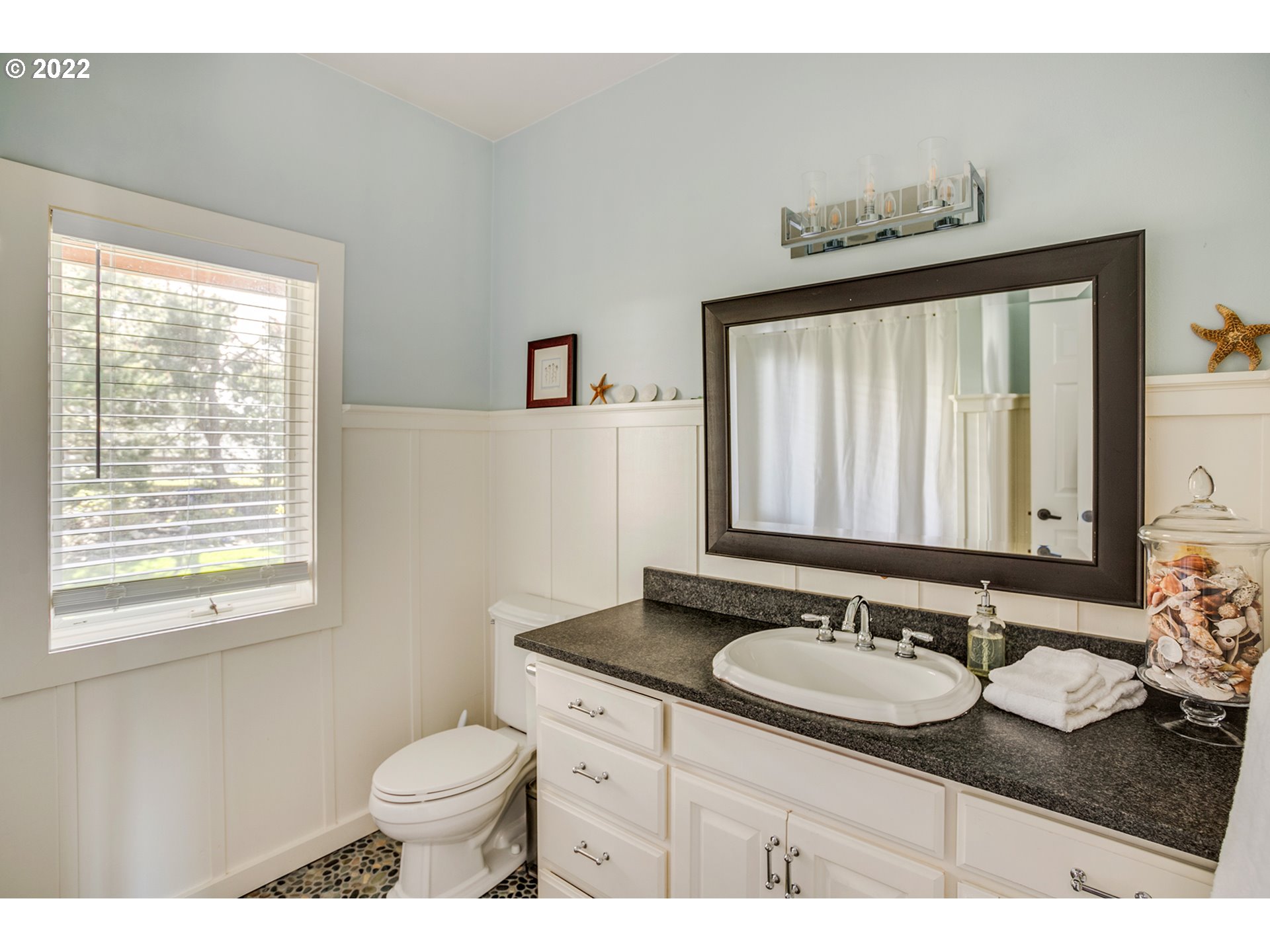 4805 High Ridge Road Gearhart, OR 97138 - Photo 19 of 29 a bathroom with a granite countertop sink toilet and mirror