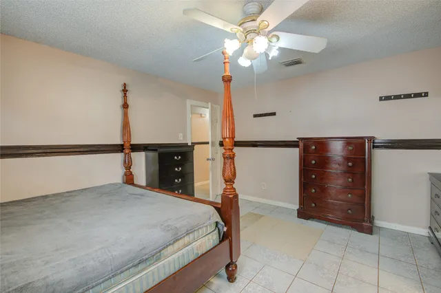 a bedroom with a bed and a ceiling fan