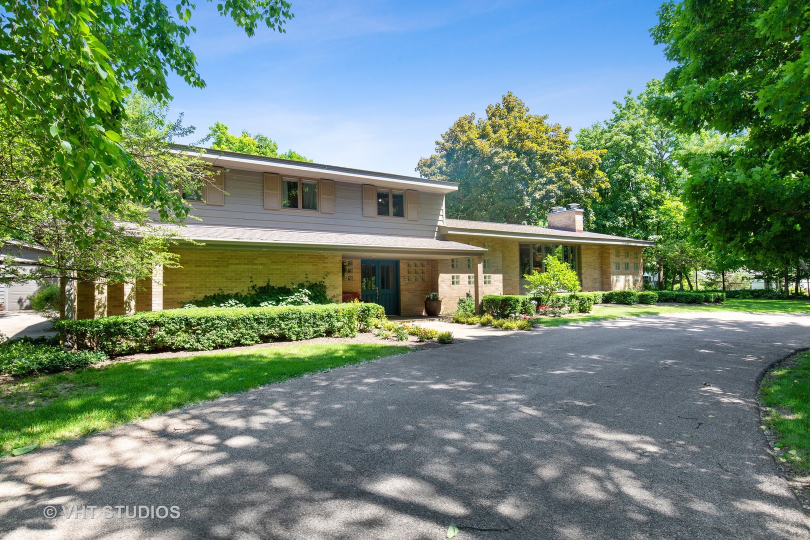 a front view of a house with a yard and a garden
