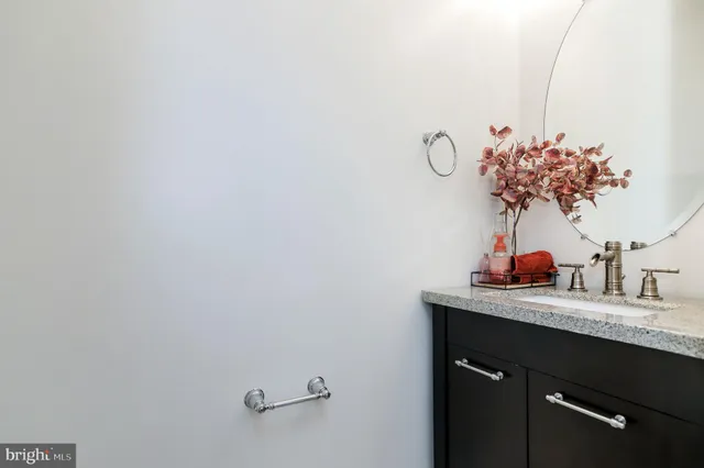 a bathroom with a granite countertop sink a mirror and vanity