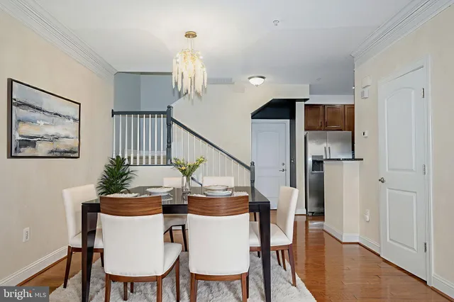 a dining room with furniture a chandelier and wooden floor