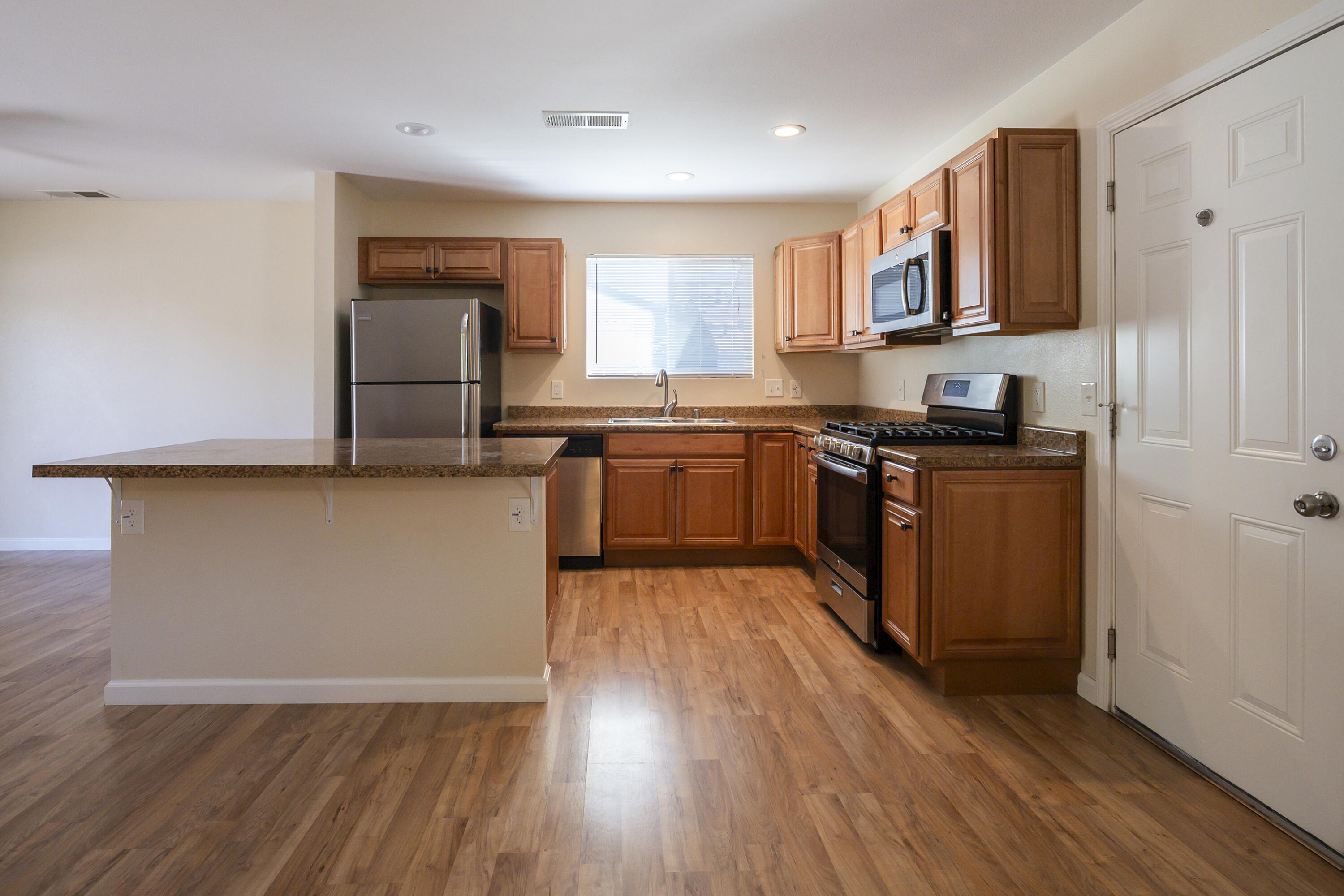 601 Green Street Willows, CA 95988 - Photo 2 of 23 a kitchen with stainless steel appliances granite countertop a stove top oven a sink dishwasher and a refrigerator with wooden floor