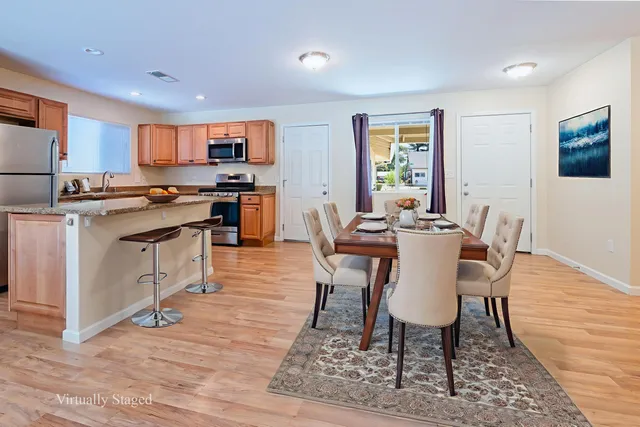 a view of a dining room with furniture a rug and wooden floor