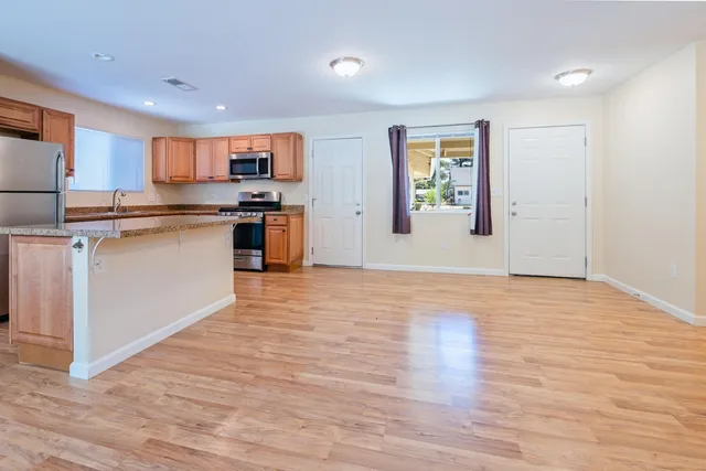 a view of kitchen with wooden floor and electronic appliances