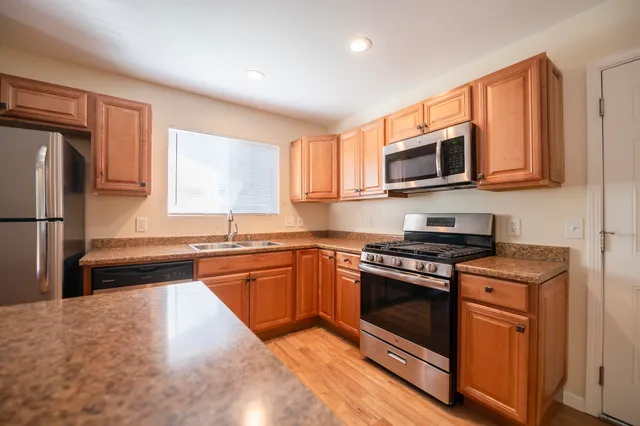 a kitchen with stainless steel appliances granite countertop a stove sink microwave and refrigerator