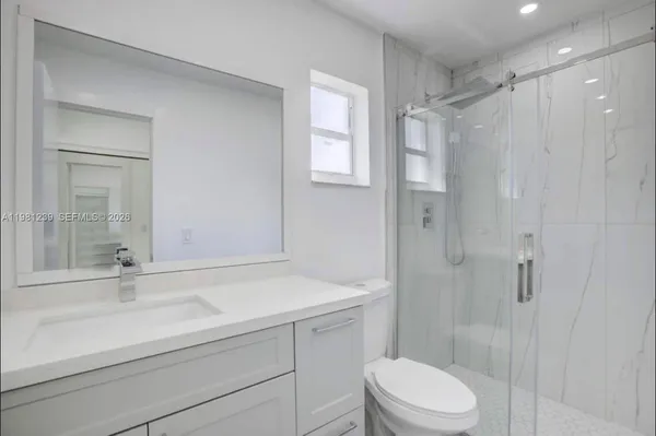 a bathroom with a sink a toilet and shower