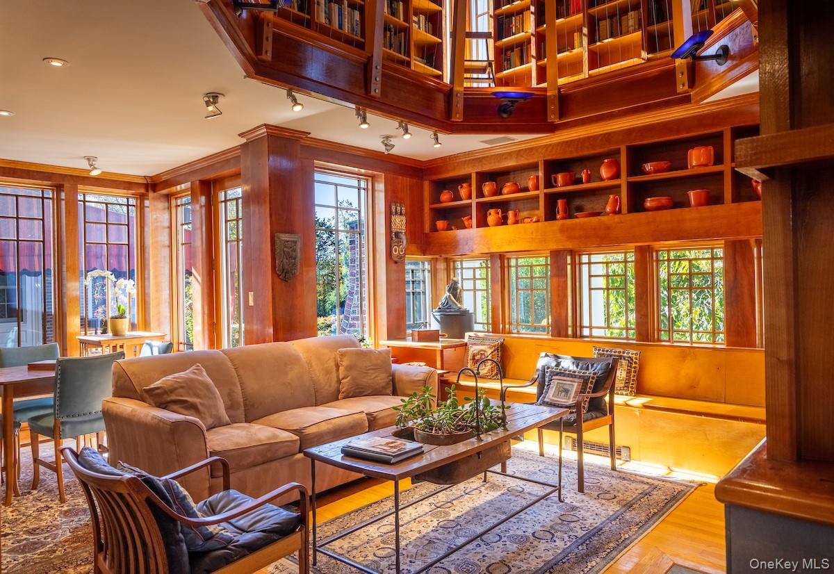 a living room with furniture a large window and wooden floor