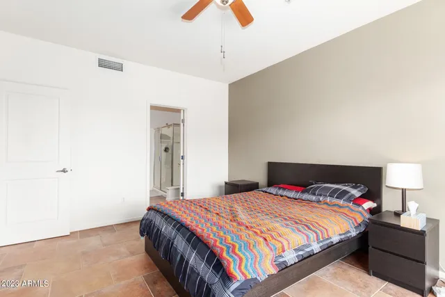 a bedroom with a bed and a painting on the wall