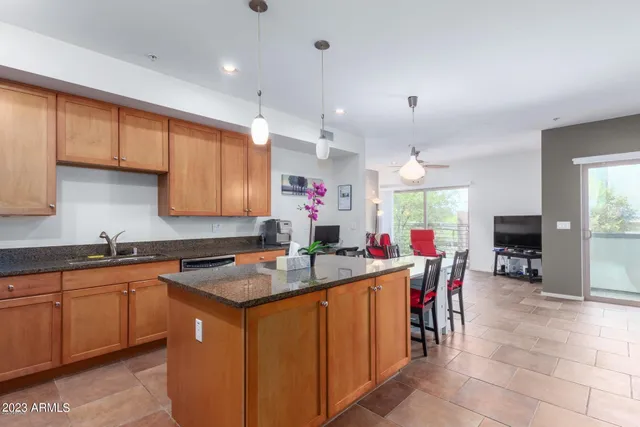 a kitchen with stainless steel appliances kitchen island granite countertop a dining table and chairs