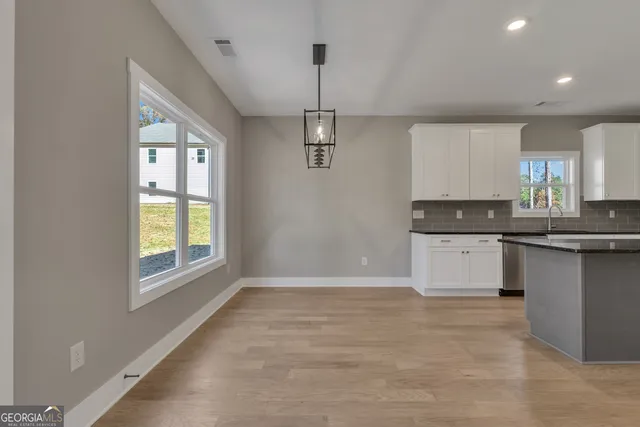 a view of a livingroom with wooden floor and staircase