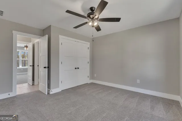 an empty room with a window and a fan