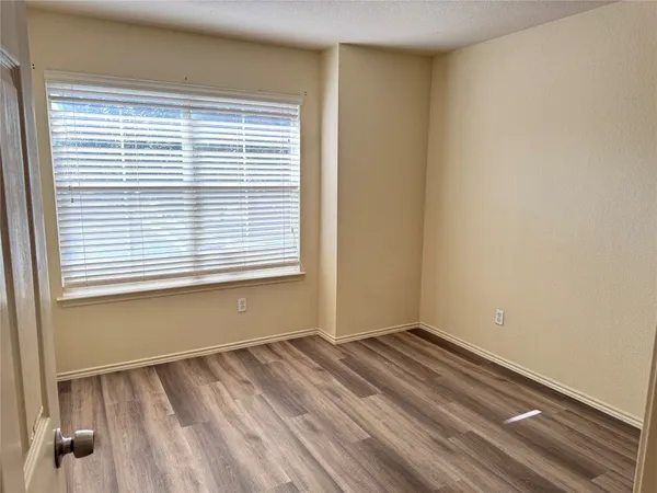 a view of a room with wooden floor and a window