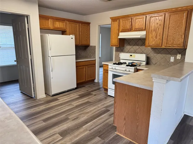 a kitchen with kitchen island granite countertop wooden cabinets a sink and dishwasher