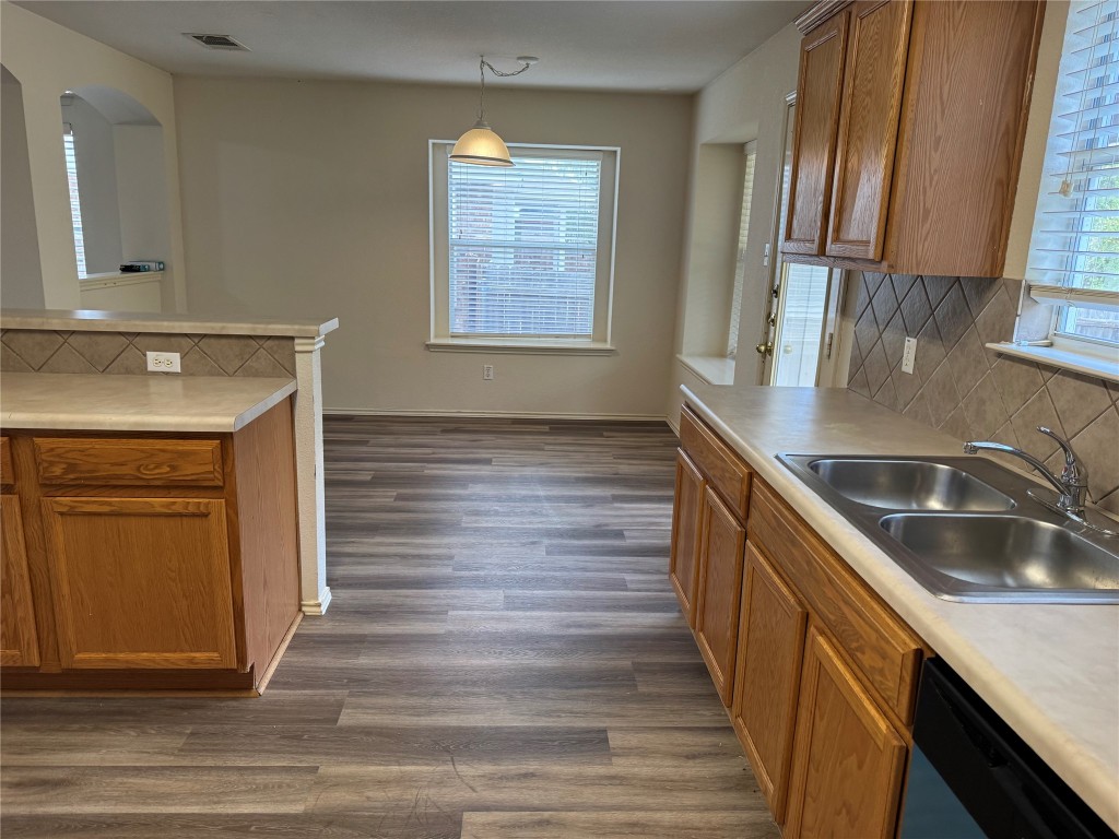 501 Grey Feather Court Round Rock, TX 78665 - Photo 7 of 28 a kitchen with kitchen island granite countertop wooden cabinets a sink and dishwasher