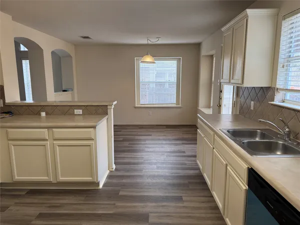 a kitchen with granite countertop wooden cabinets a sink and dishwasher