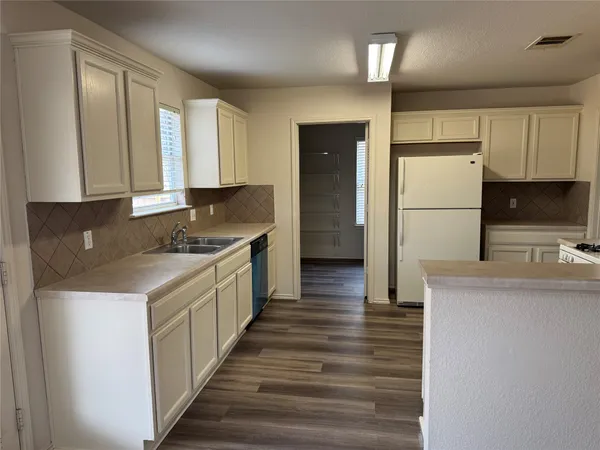 a kitchen with granite countertop a refrigerator and a stove top oven