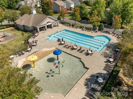 swimming pool view with large trees and buildings in the background