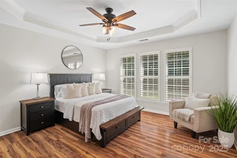 a bedroom with bed and wooden floor