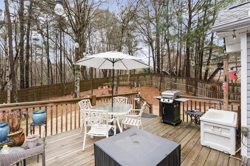 60 Sugar Birch Way Dallas, GA 30132 - Photo 20 of 31 a view of a patio with couches table and chairs under an umbrella with wooden floor
