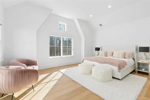 a spacious bedroom with a bed and wooden floor