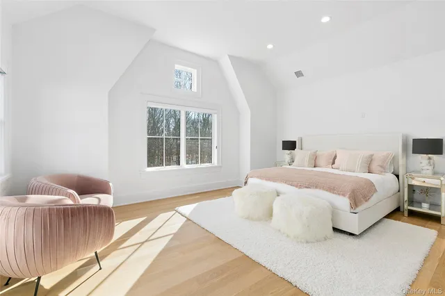 a spacious bedroom with a bed and wooden floor